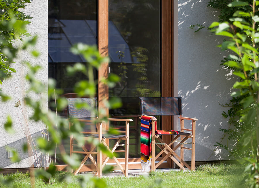 Blick aus dem Zimmer durch die Glastür auf Terrasse und Garten